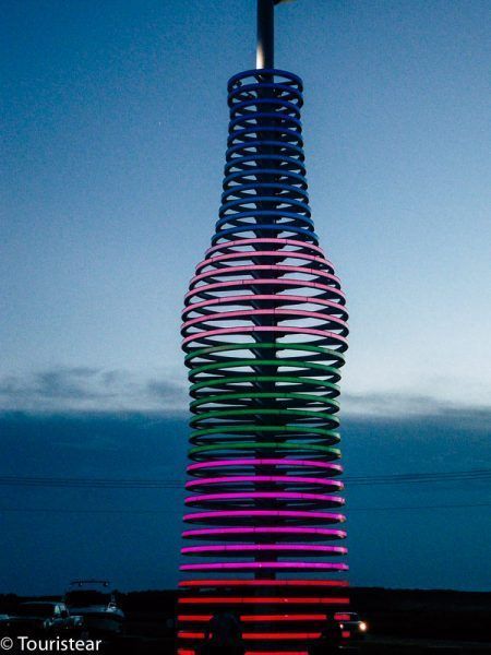 A neon lights shaped like a soda bottle along Route 66 in Oklahoma