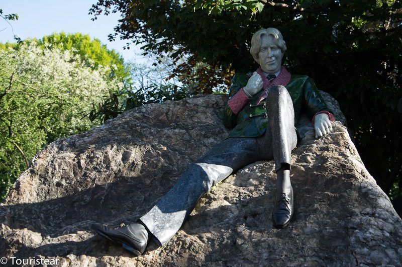 Oscar Wilde Statue sit on a rock
