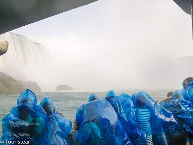 Las cataratas del niágara desde el barco y la gente con los típicos chubasqueros azules