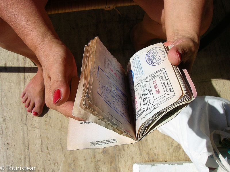 Mujer con pasaporte con sellos en la mano