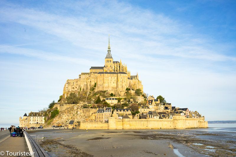 Mont Saint Michel, of Normandy, France under cloudy bright blue skies