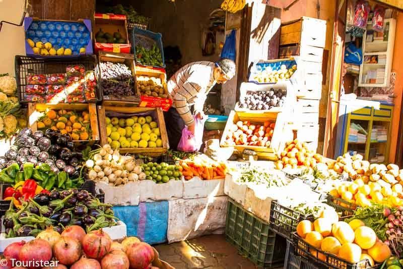 Fruit store selling fruits on crates, buying one will help save money while planning a trip in Morocco