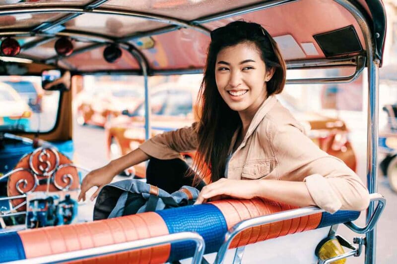turista asiática en un tuk tuk en Bangkok