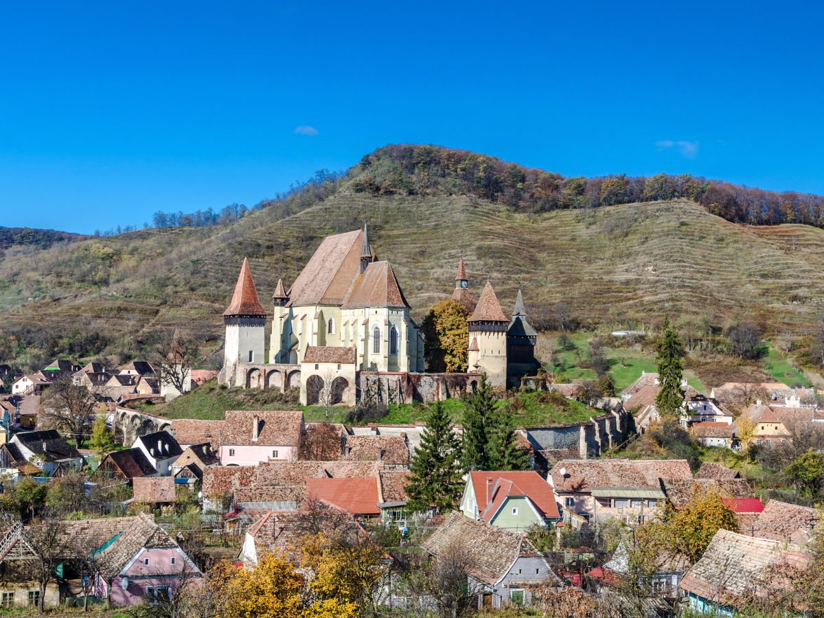 The Biertan Fortified Church surrounded by houses in Transylvania under clear blue skies