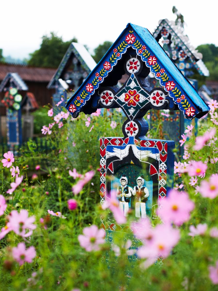 Colorful tombs of the Merry Cemetery surrounded by flowers in Transylvania