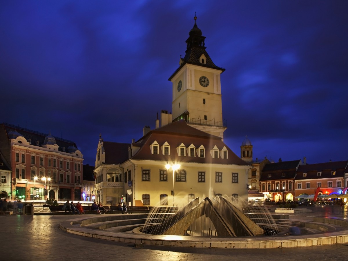 The Piața Sfatului (Council Square in Brasov) at night time featuring its fountain with deep seats