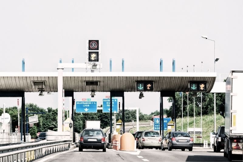 toll booths with cars that you want to save money on a road trip