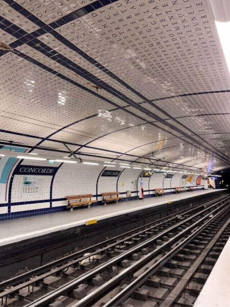 rails of the concordia underground metro with white tiled roof extending to the floor