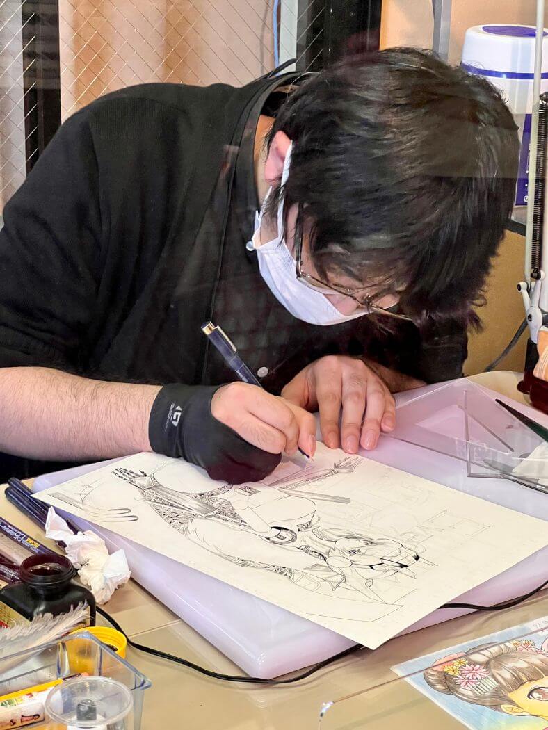 mangaka dibujando en el museo del manga de Kioto