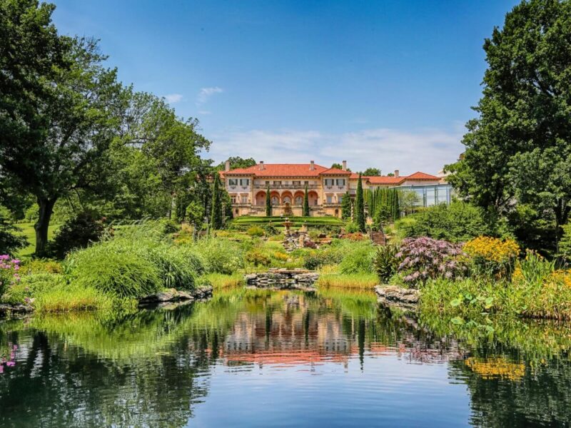 A water body in front of the Philbrook Museum of Art under bright blue skies