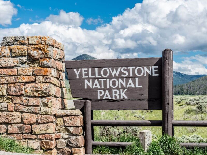 Señal del Parque Nacional de Yellowstone delante del parque, uno de los destinos de viaje por carretera en EE.UU.