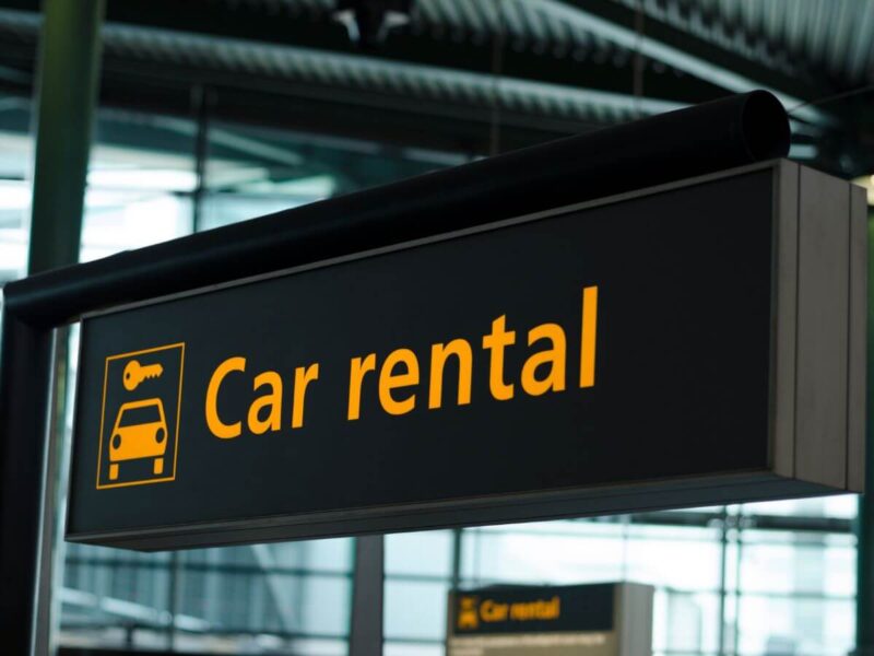 A car rental sign with yellow text and black signage in Chicago