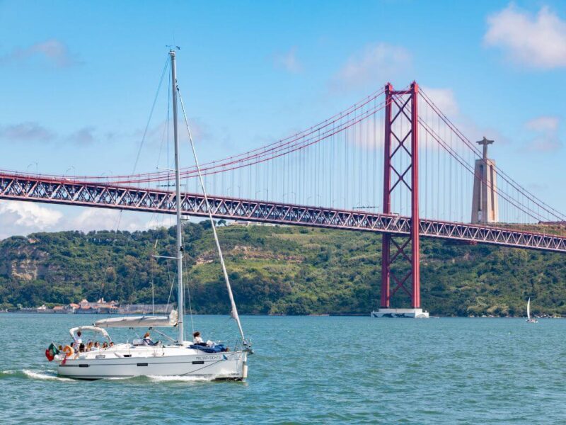 a white boat and the red bridge in Lisbon