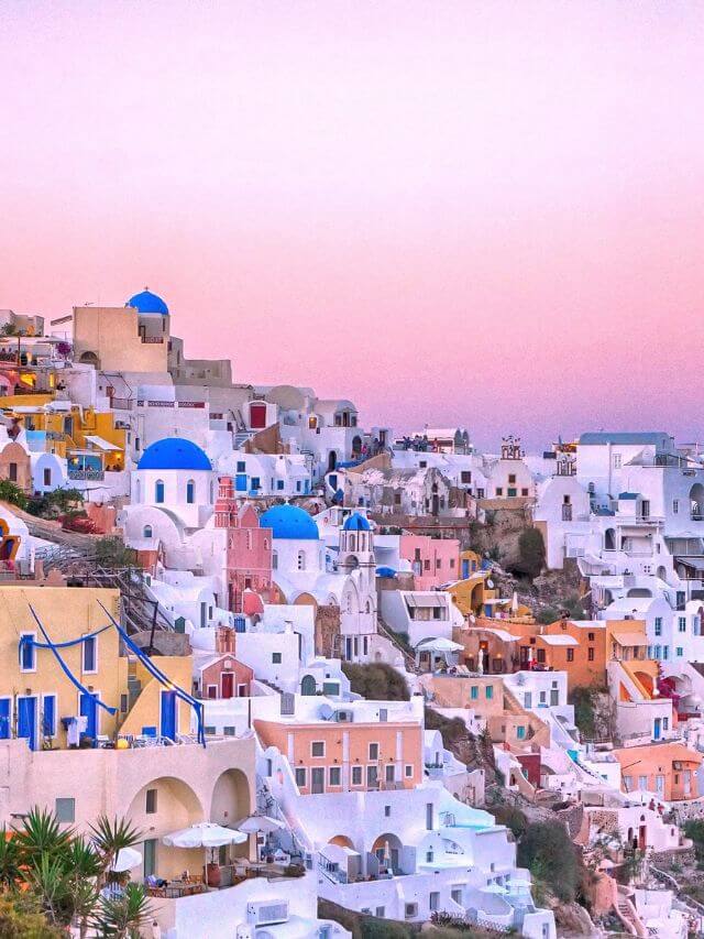 White houses with blue roofs at sunset in Santorini